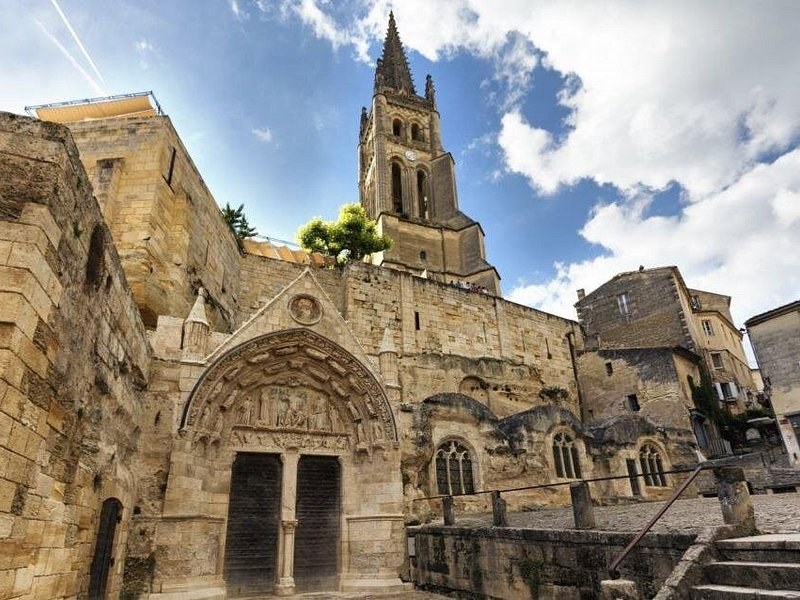 The carved door of Saint-Émilion's rock-hewn church under its bell tower