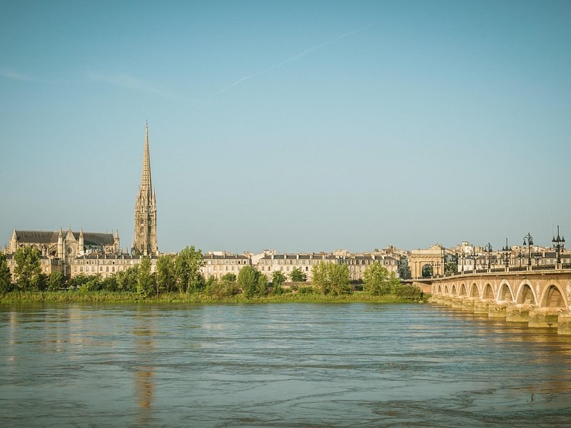 The Saint-Michel spire seen across the Garonne, the arches of the Pont de Pierre on the right