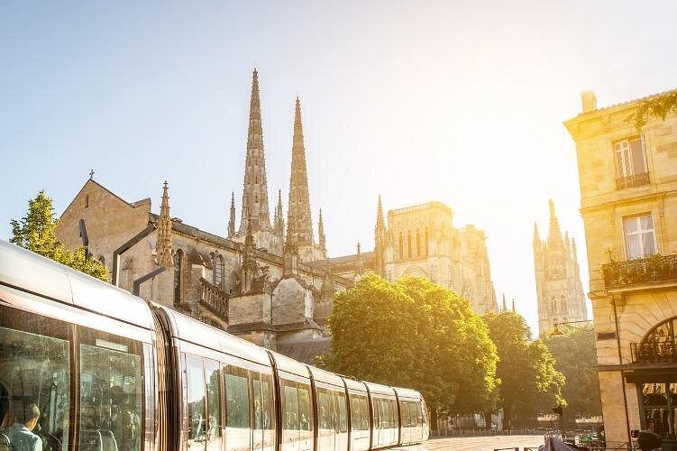 A tram passing below the twin spires of the cathedral, the Pey-Berland tower to the right